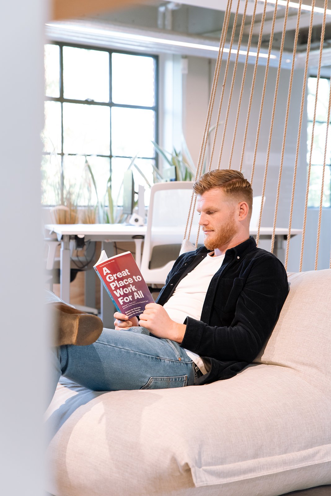 Man leest boek A Great Place To Work For All op het kantoor van Great Place To Work