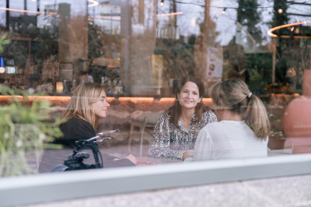 Drie vrouwelijke collega's praten met elkaar