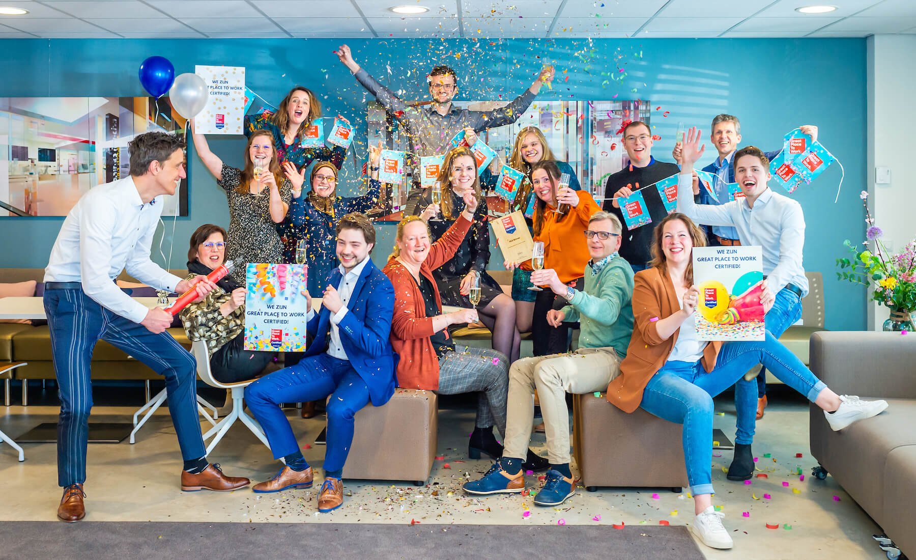 Medewerkers van HLB Blömer poseren met Great Place To Work certificaat met confetti