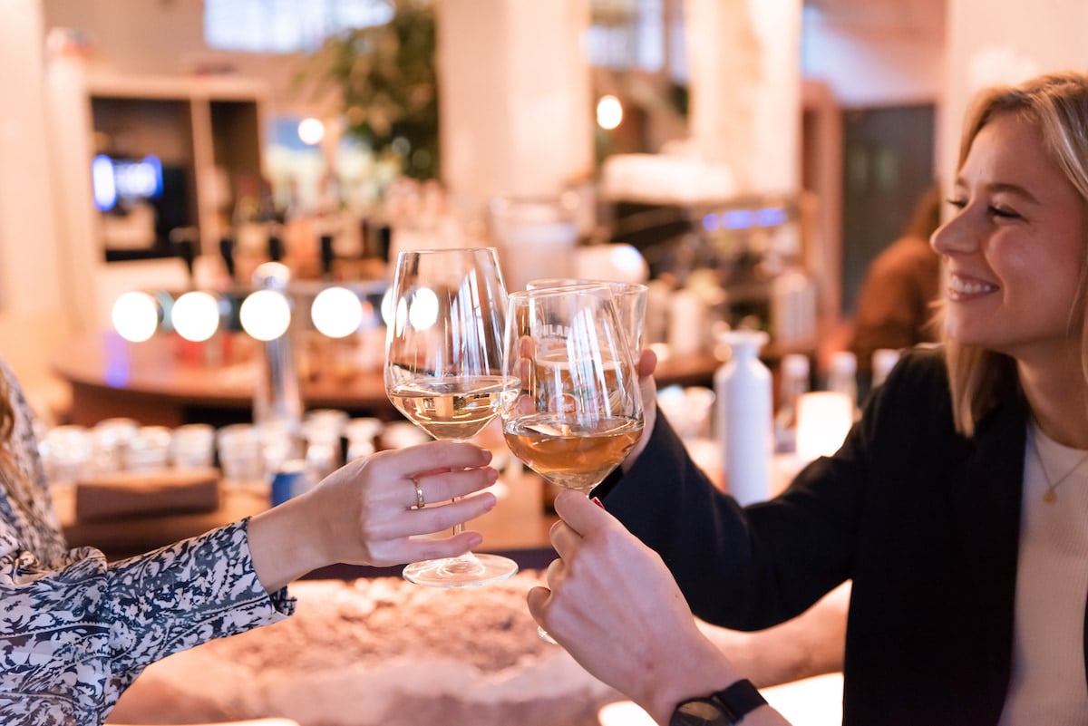 Vrouwen vieren succes door te proosten met glas wijn
